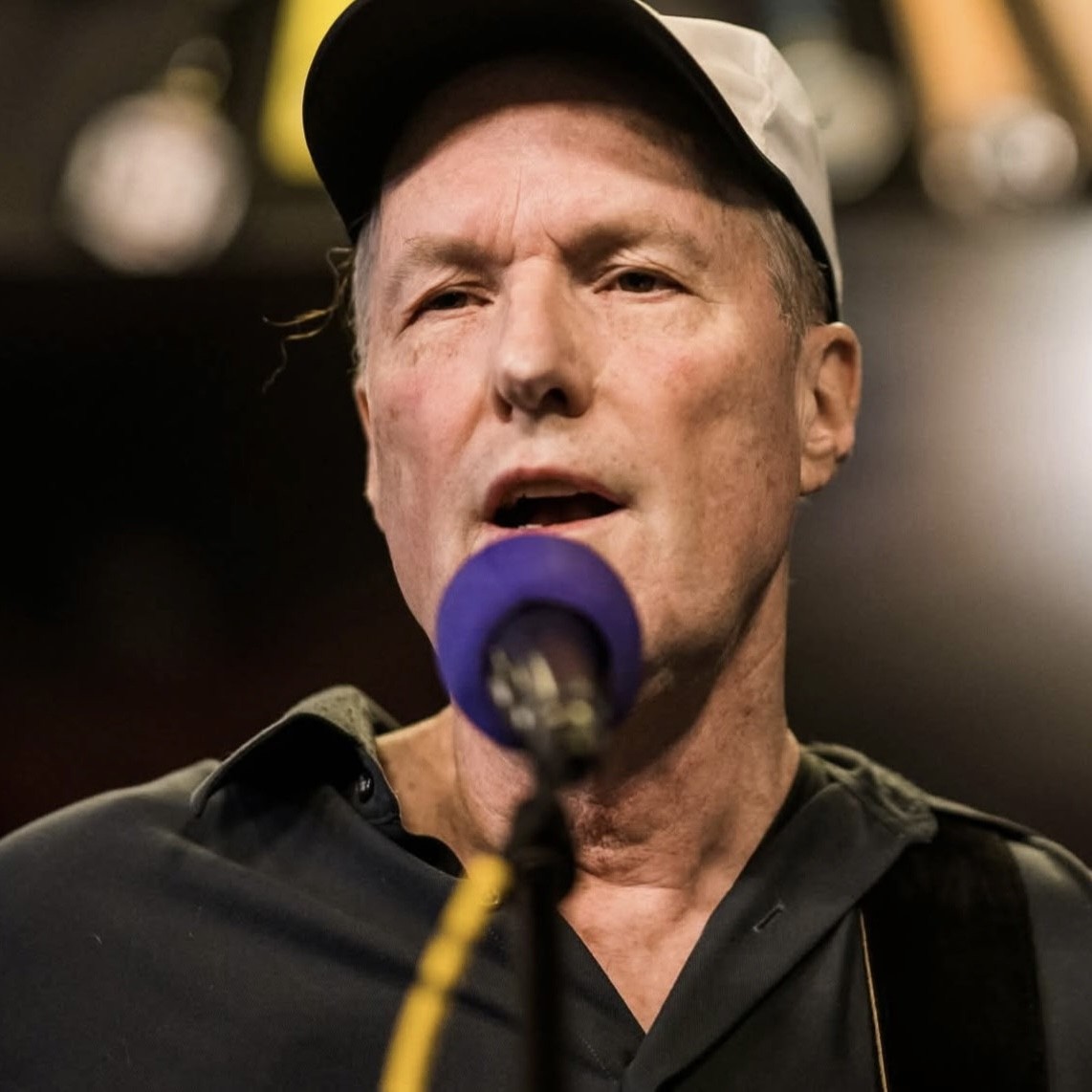 Mark Weber singing into a microphone